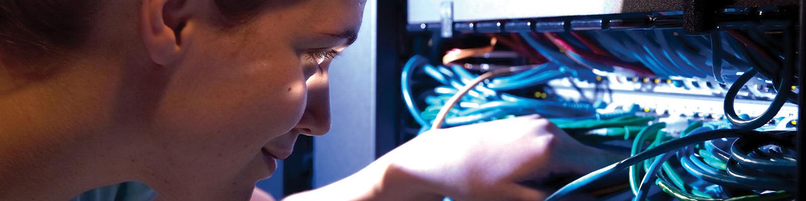 student adjusting networking wires